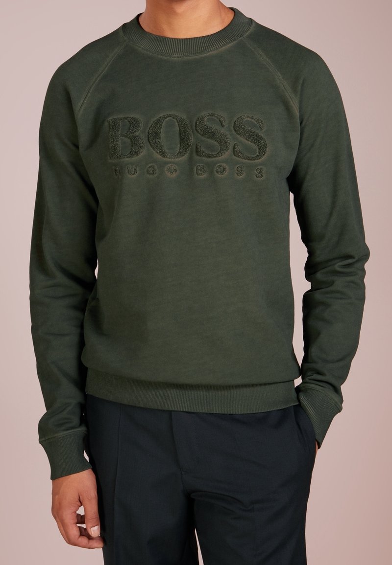 Zelená mikina s kulatým výstřihem, na přední straně s vyvýšeným logem "BOSS". Vyrobena z měkké tkaniny s žebrovanými manžetami a lemováním.