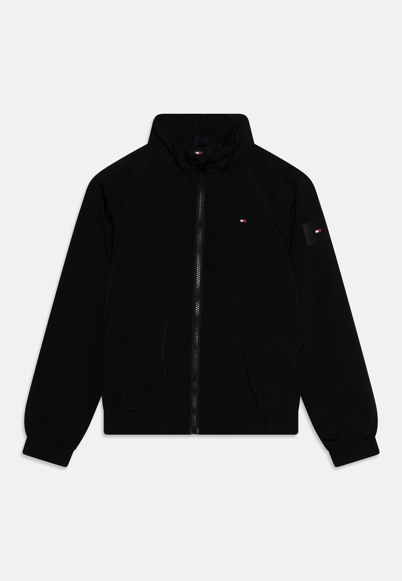 Sort letvægtsjakke med ståkrave, lynlås foran, elastiske manchetter og to sidelommer. Har et lille logo på brystet og ærmet.