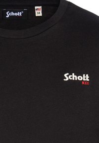 T-shirt nera a maniche corte con colletto rotondo. Presenta il logo ricamato "Schott" in bianco e "N.Y.C." in rosso. Realizzata in un tessuto morbido.