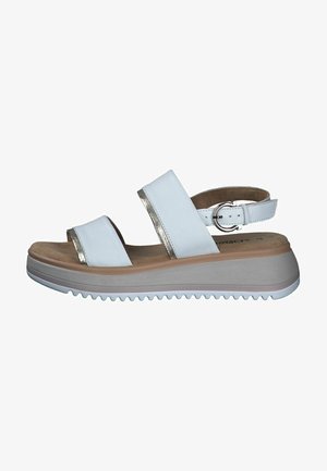 Weiße Sandalen mit zwei breiten Riemen, die metallische Akzente aufweisen, einem gepolsterten Fußbett und einer geriffelten, hellen Keilsohle. Mit Schnallenverschluss an der Ferse.