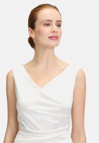 Robe sans manches en satin blanc avec un décolleté en V, présentant un corsage ajusté et une texture lisse, mettant en valeur des détails de drapés élégants.