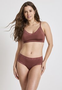 BH och trosor i en djupt vinröd färg, med mjuk spetskant längs kanterna. Materialet är slätt med en sömlös design för komfort.