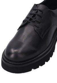 Zwarte leren schoen met een gladde afwerking, ronde neus en vetersluiting. Voorzien van een dikke, gestructureerde zwarte rubberen zool.
