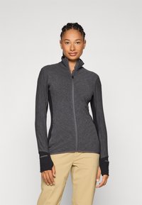 Gray zip-up jacket with a textured fabric and black side panels. Features thumbholes at the cuffs and a high collar for added coverage.