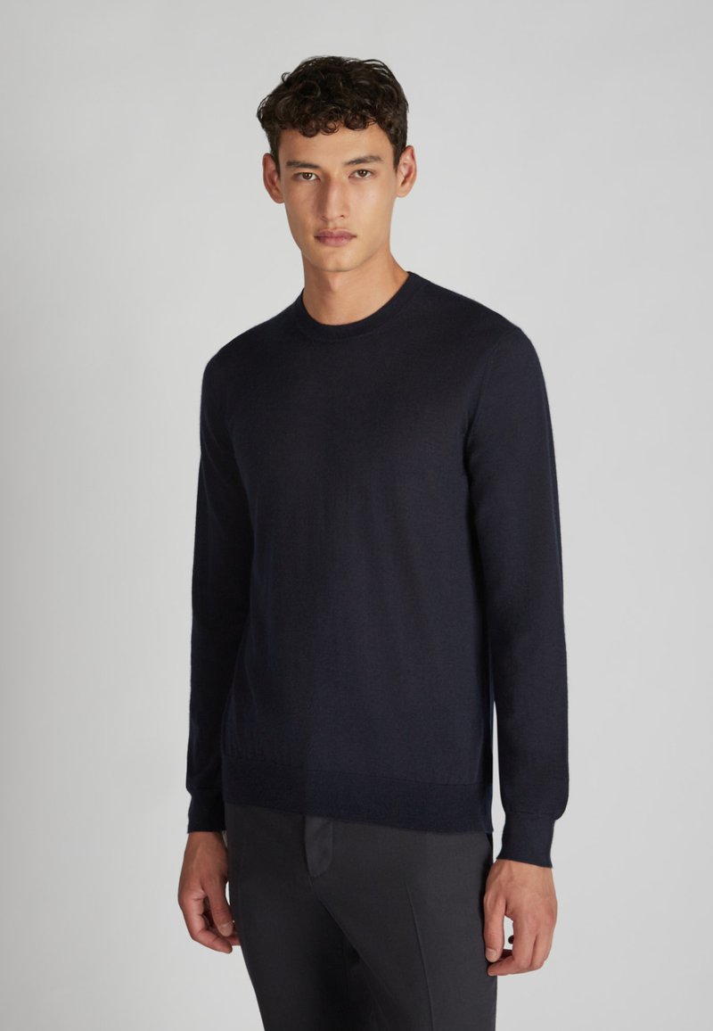 Marineblaues Sweatshirt aus glattem Stoff mit Rundhals, langen Ärmeln und gerippten Bündchen sowie Saum. Einfaches, minimalistisches Design.