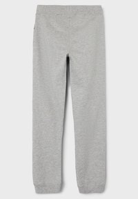 Šedé tepláky vyrobené z měkkého, hladkého materiálu. Mají přiléhavý pas a manžety na kotnících. Jednoduchý design bez ozdob.