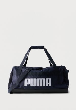 Borsa sportiva da viaggio blu navy con base nera, tracolla, manici e grande logo bianco "PUMA" sul lato su sfondo uniforme.