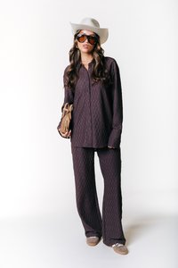 Set di camicia e pantaloni a fantasia viola realizzato in tessuto testurizzato, abbinato a un cappello da cowboy grigio chiaro e occhiali da sole oversize.