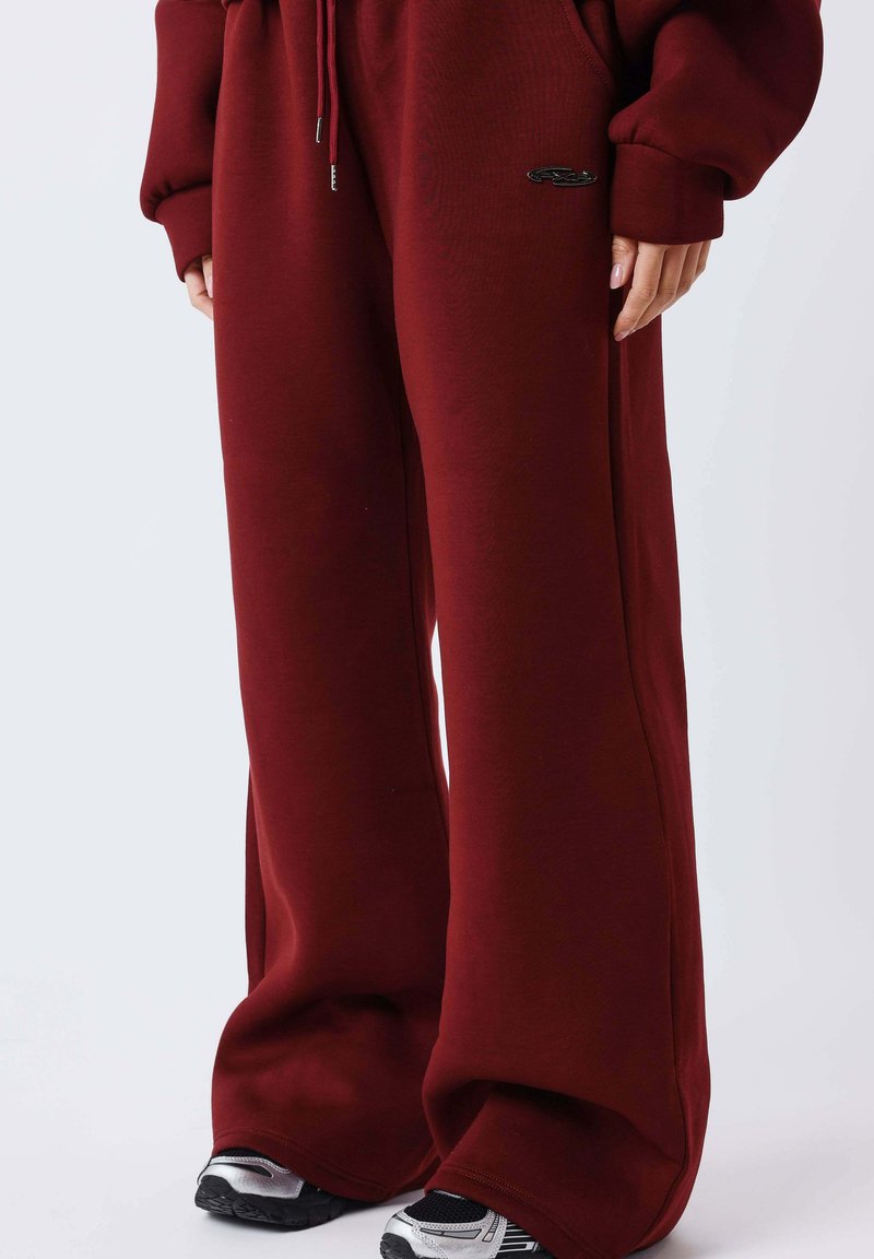 Bordeaux rode sweatpants met wijde pijpen en een zachte textuur, voorzien van een verstelbare taille met trekkoord en een klein zwart logodetail.