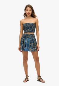 Ensemble deux pièces à imprimé paisley bleu, comprenant un haut sans bretelles et une jupe assortie avec une taille élastique et des poches latérales.