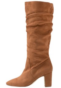 Botte en daim marron, hauteur genou, décontractée, avec un bout pointu et un talon bloc moyen, présentant des coutures subtiles et une texture lisse.