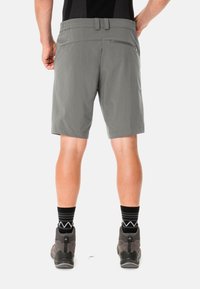 Pantalones cortos de senderismo grises de material ligero y flexible; cuenta con un bolsillo con cremallera y una cinturilla elástica para mayor comodidad.