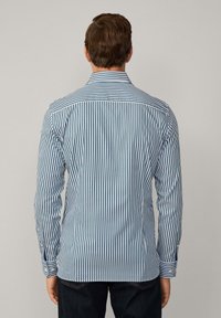Striped shirt featuring blue and white vertical stripes, button-down collar, and long sleeves, made from a smooth fabric with a tailored fit.
