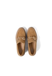 Mocassini in camoscio beige con texture liscia, punta rotonda e dettagli in catena dorata sulla tomaia. Suola leggera per il massimo comfort.