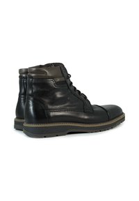 Botas de cuero negras hasta el tobillo con un acabado suave, diseño de cordones, suelas resistentes y un cuello marrón en contraste en la parte superior.