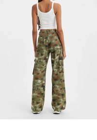 Spodnie cargo w kamuflażu w odcieniach zieleni i brązu, szerokie nogawki z kieszeniami bocznymi, wykonane z wytrzymałego materiału, zaprezentowane z tyłu.