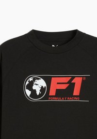 Sort bomulds t-shirt med et stort rødt "F1" logo og globusgrafik med hvide accenter, rund hals og raglanærmer.