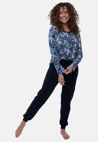 Blomsterprint langærmet top i blå og hvid, parret med marineblå joggers med elastisk talje. Blødt stof med en afslappet pasform og tilspidsede ærmer.
