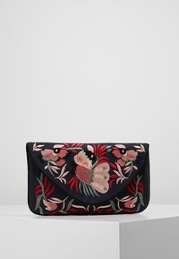 Navy kankaan clutch, jossa on kukkakuviointi vaaleanpunaisella, punaisella ja vihreällä. Ominaisuuksiin kuuluu kirjeen muotoinen läppä ja sileä pinta.