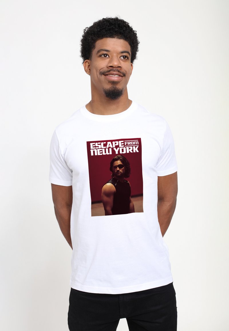 Hvid kortærmet t-shirt med et kvadratisk grafisk motiv af en mand i en sort tanktop, med teksten "ESCAPE from NEW YORK" i fed rød skrift.
