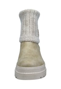 Botín de tobillo de color beige claro con puño de punto texturizado, suela de goma y forma aerodinámica, con una superficie lisa y punta redondeada.