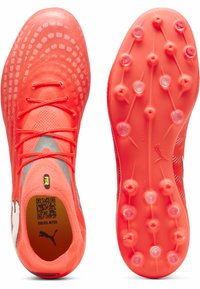 Kirkkaan oranssit jalkapallokengät, joissa on teksturoitu verkkopäällinen, nauhallinen suljenta ja kontrastivärinen valkoinen logo. Pohjassa on useita nastoja pitoa varten.