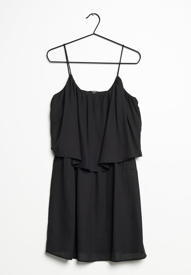Robe noire sans manches avec fines bretelles suspendue sur un cintre noir sur un fond blanc.