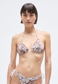 Hnedobiele kvetinové bikiny s trojuholníkovým vrchným dielom so zaväzovaním za krkom a spodným dielom so zaväzovaním na bokoch; vyrobené z hladkej látky.
