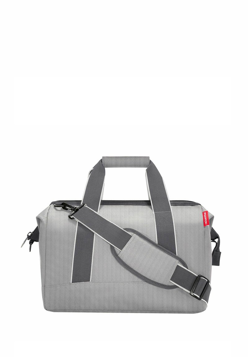 Graue Stoff-Duffle-Tasche mit zwei Obergriffen und einem abnehmbaren Schultergurt. Verfügt über kontrastierende weiße Nähte und einen Reißverschlussverschluss.