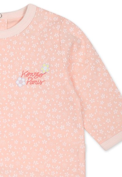 Chemise rose à manches courtes avec un motif floral blanc en tout point. "Kenzo Paris" est imprimé en rouge avec des accents floraux colorés.
