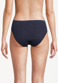 Mutande in cotone blu navy con una texture liscia, design a vita bassa e taglio minimalista. Presentano cuciture piatte e nessun marchio visibile.