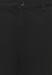 Pantalons noirs avec une texture lisse, une fermeture à bouton à l'avant et des détails de couture subtils. La taille est dotée de passants de ceinture standard.