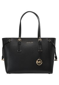 Bolso tote de piel negra de Michael Kors con asas dobles y charm de logo en tono dorado colgando de la correa frontal.