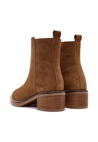 Stivaletti alla caviglia in suede marrone con tacco a blocco di media altezza, pannelli laterali elasticizzati e linguette per facilitarne l'indossamento, caratterizzati da una texture liscia e un design classico.