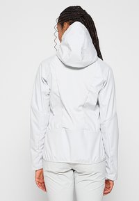 Jasnoszara kurtka z kapturem, z fakturowanym tylnym panelem, elastycznym dołem i gładkimi rękawami. Charakteryzuje się dopasowanym krojem i minimalistyczną estetyką.