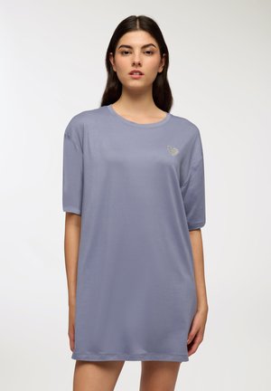 T-shirt oversize in un delicato lavanda con maniche corte. Presenta un piccolo emblema a forma di cuore argentato sul petto. Tessuto morbido e liscio.