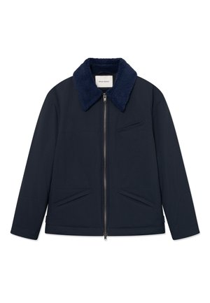 Marineblaue Jacke mit Reißverschluss, texturiertem, dunklerem blauen Kragen und drei vorderen Schlitztaschen, mit Wood Wood-Label im Nacken.