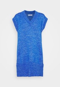 Ärm-, blå stickad väst med V-ringning och ribbad nederkant, som visar ett texturerat mönster av blandade blå nyanser.