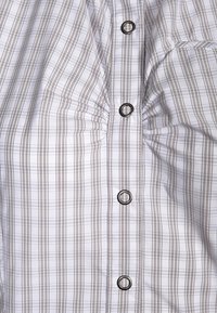 Painettu nappipaita, jossa on harmaa- ja valkoinen ruutukuosi, hienovarainen rypytys ja hopeanväriset pyöreät napit etukappaleella.