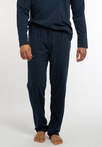 Marineblaues Langarmoberteil mit Tasche und dazugehörigen Joggingpants mit Kordelzug, aus weichem Stoff, mit lockerer Passform und minimalistischem Design.