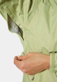 Jasnozielona kurtka z bocznym zamkiem błyskawicznym i regulowanymi mankietami. Wykonana z gładkiego, wodoodpornego materiału o subtelnym połysku.