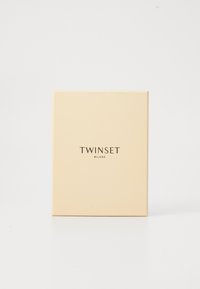 Square, pale beige box with smooth texture. Front displays "TWINSET MILANO" in simple dark typography. Clean, minimalistic design.