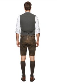 Grijze, gestructureerde vest over een wit shirt, gecombineerd met bruine lederhosen shorts, kniehoge donkere sokken en bruine leren schoenen.