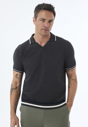 Short-sleeve, dark gray polo shirt with a textured knit. Features a V-neck, contrasting white striped collar and cuffs, and a fitted silhouette.