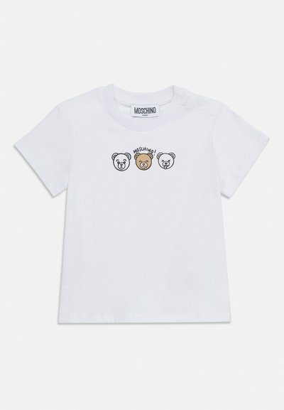 Λευκό παιδικό T-shirt με εικονογράφηση τριών προσώπων αρκούδων και το κείμενο "Moschino!" πάνω από την καφέ αρκούδα στο κέντρο, με κουμπιά στους ώμους.