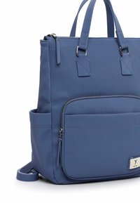 Blue ribbed fabric backpack with dual top handles, a zipper closure, front pocket, and side pocket. Features silver hardware accents.
