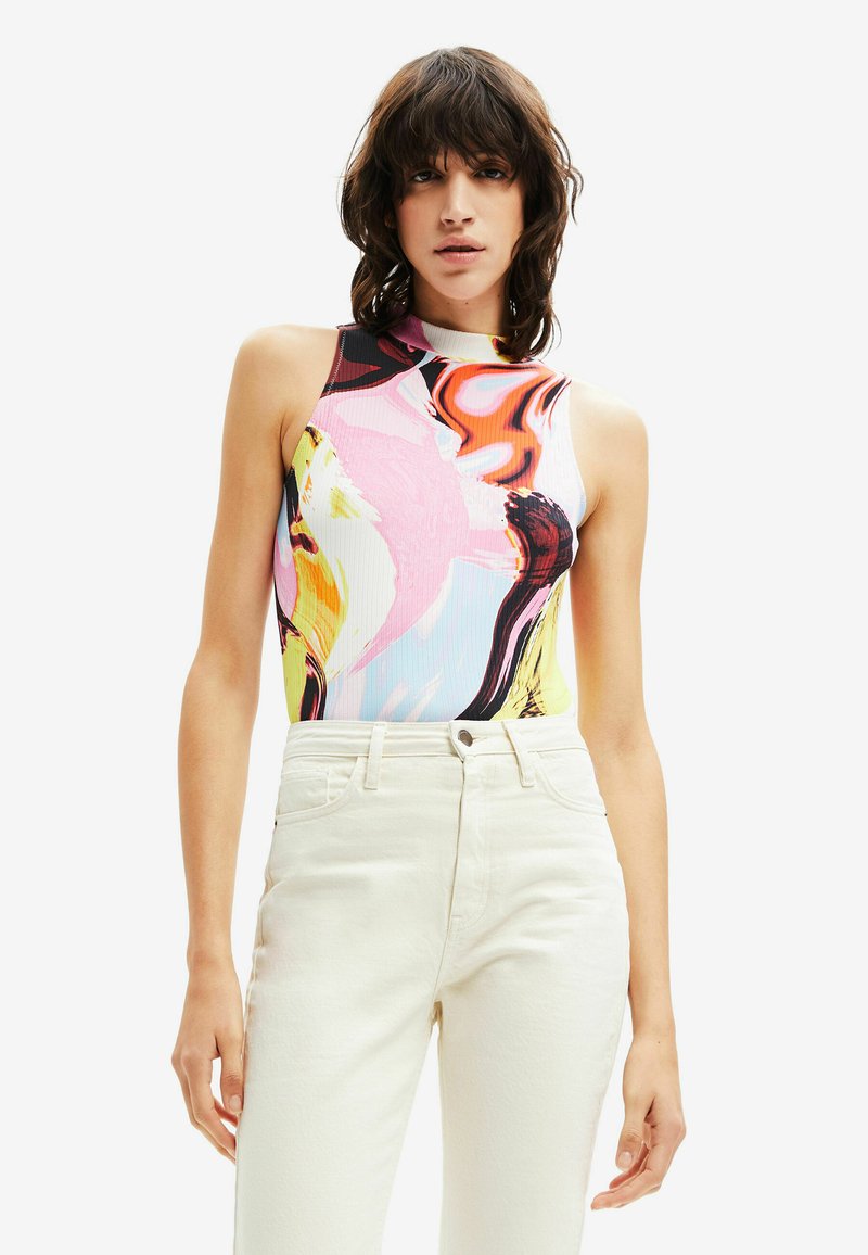 Kleurvolle bodysuit met abstracte patronen in roze, geel en zwart, met een hoge halslijn. Gecombineerd met hoge witte jeans.