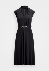 Černé šaty s vysokým límcem a detailním zavazováním, krátké rukávy typu cap, pas s páskem ozdobeným stříbrným řetízkem, splývavá áčková silueta.