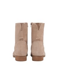 Světlé béžové semišové kotníkové boty zaoblenou špičkou, nízkým blokovým podpatkem a zipem na zadní straně. Detail s vlnitým horním okrajem.