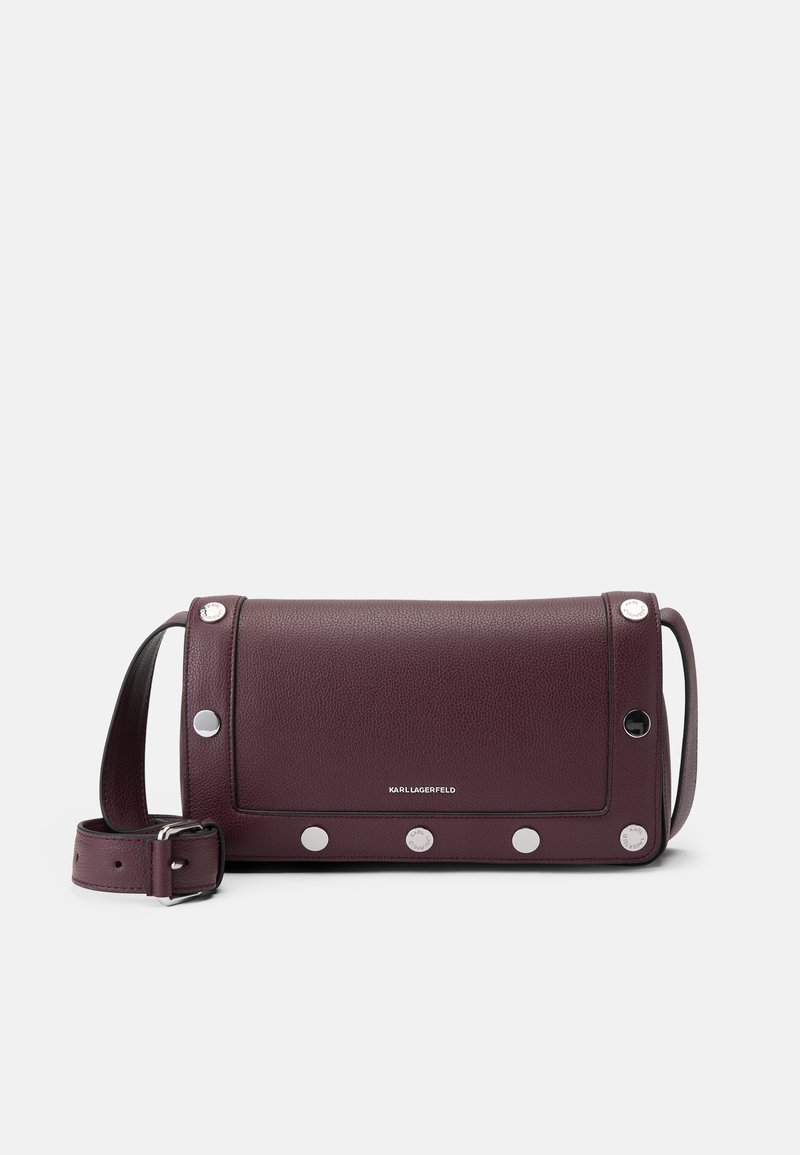 Borsa a tracolla in pelle bordeaux con flap pieghevole, caratterizzata da borchie argentate lungo i bordi e una tracolla rimovibile. Superficie testurizzata.
